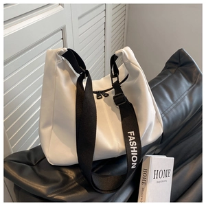 Gros plan sur la bandoulière Fashion noire et la double fermeture éclair du sac blanc