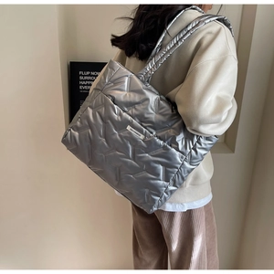 Silver metallic quilted tote bag with padded V-stitch detail shown on shoulder
