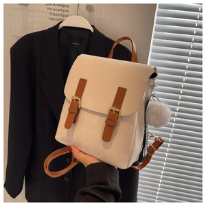 Nahaufnahme des cremeweißen PU-Leder-Rucksacks mit gesteppter Textur und Bommel-Anhänger