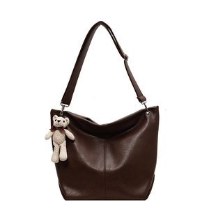 Brown faux leather tote bag with vertical stitching and cute white bear charm