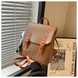 Detail eines braunen Vintage-Lederrucksacks mit Rautenprägung und dekorativen Trägern