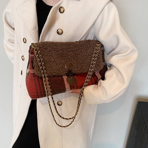 Red plaid tote bag with faux fur flap and gold chain strap worn by a female model
