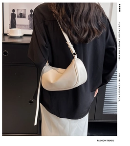Chic cream-colored crescent shoulder bag shown on model for a minimalist fashion look