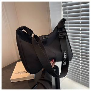 Détail du sac fourre-tout noir en nylon avec bandoulière large et zips métalliques