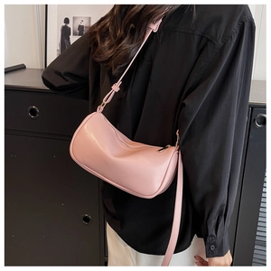 Fashionable pink PU leather shoulder bag shown on model with adjustable strap