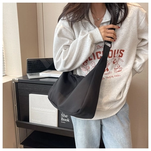 Gros plan d'un sac hobo noir porté par un mannequin pour un look quotidien et décontracté