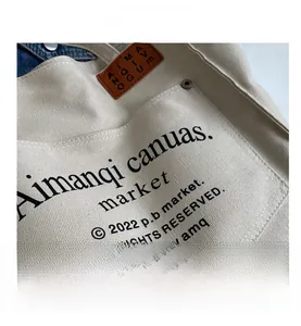Detailed close-up of cream canvas tote bag showing thick twill fabric and metal hardware