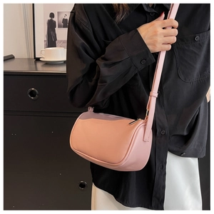 Detail of light pink cylindrical crossbody bag in premium leather with slim shoulder strap