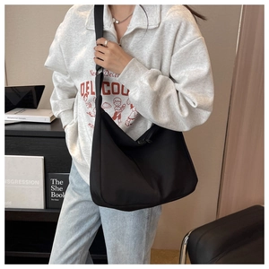 Détail d'un grand sac croissant noir en nylon imperméable avec large bandoulière réglable