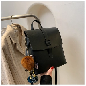 Dettaglio zaino in pelle nera con ciondolo in peluche e nastro a pied-de-poule