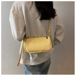 Detail of light yellow PU leather crossbody bag with adjustable strap and gold zipper