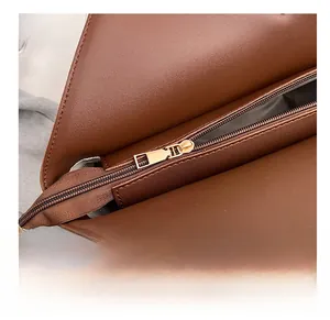 Détail de la fermeture éclair dorée lisse et de la doublure interne d'un sac cabas brun