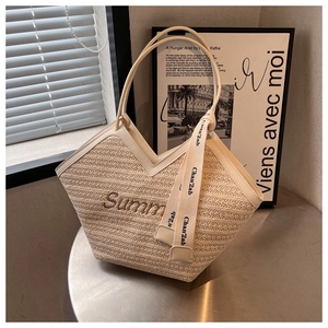 Détail du sac cabas en paille avec broderie Summer et ruban élégant noué sur l'anse