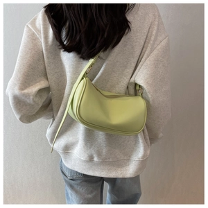 Modern light green baguette bag with adjustable strap shown on model for size and fit