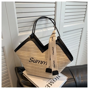 Détail d'un cabas en paille avec des poignées en cuir et un design logo Summer