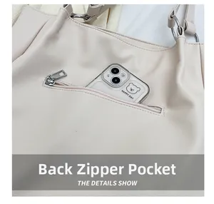 Dettaglio della tasca posteriore con zip su borsa in pelle beige per contenere telefoni