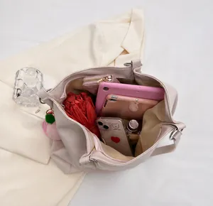 Vista dall'alto dello spazioso scomparto interno di questa borsa tote con oggetti