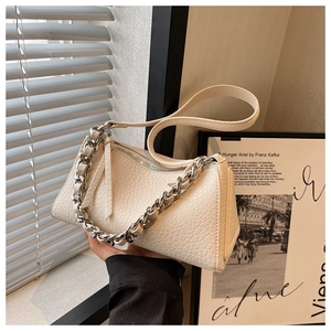 Detalle del bolso almohada de cuero plisado blanco roto con cadena plateada y correa