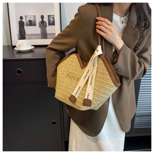 Détail du sac cabas en paille avec broderie Sunny et finitions en cuir marron