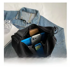 Detail of spacious black canvas crossbody bag interior showing tablets and wallets