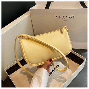 Detailed shot of cream PU leather pillow bag with gold zipper in gift box packaging