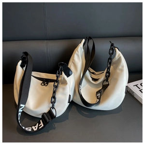 Detail of white crescent bag with black chain and fashion lettered wide shoulder strap