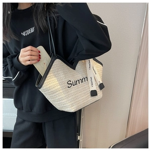 Détail du sac cabas en paille tissée avec ouverture en V et broderie texte Summ