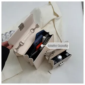 Macro view of beige crossbody bag internal capacity with multiple organized compartments
