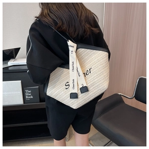 Détail d'un grand sac cabas d'été tissé avec bordures en cuir noir et ruban décoratif