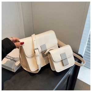 Detail of cream crossbody bag set with silver metallic lock and matching coin purse