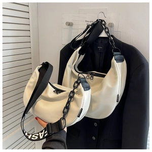 Detail of off-white crescent crossbody bags with wide fashion straps and chain accents