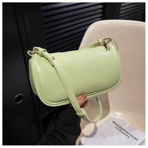 Detail view of mint green cylinder shoulder bag with golden hardware and zipper pendant