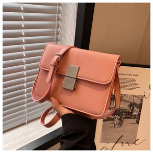 Close-up of a soft pink leather flap shoulder bag featuring a silver textured metal lock