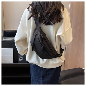 Back view of a black crescent nylon crossbody bag with dual zippers and adjustable strap