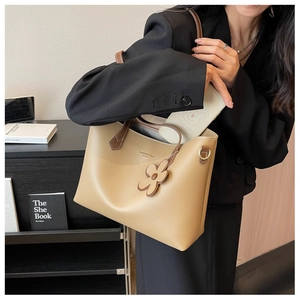 Detail view of stylish large capacity beige tote bag showing side D-ring and texture