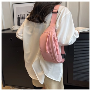 Detail of light pink waterproof chest bag with woven zipper pull and sturdy strap buckle