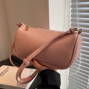 Minimalist pink cylinder crossbody bag with golden zipper and smooth faux leather finish