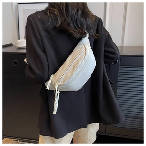Chic cream canvas belt bag worn by a model in a stylish street style fashion shot
