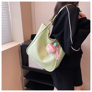 Detail view of large mint green tote bag with cute pink charm for daily commuting