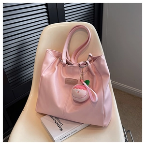 Dettaglio borsa tote rosa con ciondolo a pesca e logo MULAIBAG in ecopelle di qualità