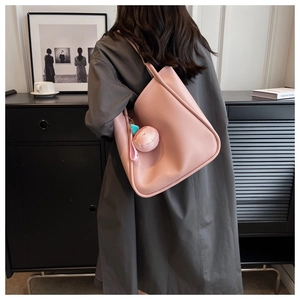 Detail of pink PU leather tote bag with a cute 3D plush peach charm for women