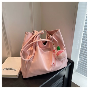 Dettaglio della borsa tote in ecopelle rosa chiaro con ciondolo a pesca in peluche e tracolla