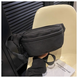 Detail view of minimalist black canvas waist bag with adjustable strap and braided zipper pull
