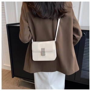 Modern white PU leather crossbody bag with silver metallic buckle on a model in a suit