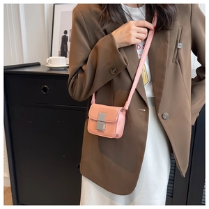 Detail view of pink mini crossbody bag with rectangular silver clasp on model