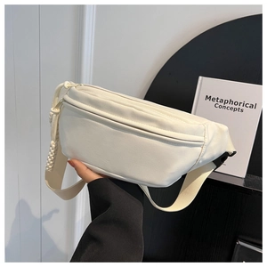 Close-up of a white canvas waist bag featuring a wide strap and woven zipper detail