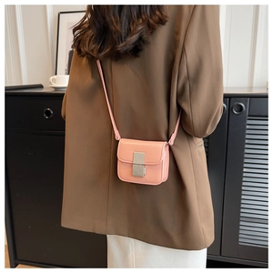 Light pink mini crossbody square bag with silver metal lock shown on a model's back