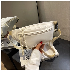 Detail of white nylon waist bag featuring multiple zip pockets and woven cord zipper pull