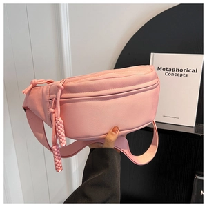 Pink canvas crossbody waist bag with textured fabric and woven rope zipper pull