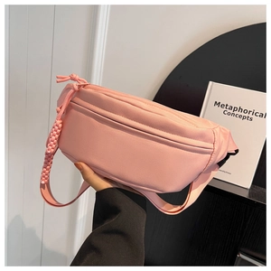 Close-up of pink nylon crossbody bag featuring woven rope zipper pull and waterproof fabric